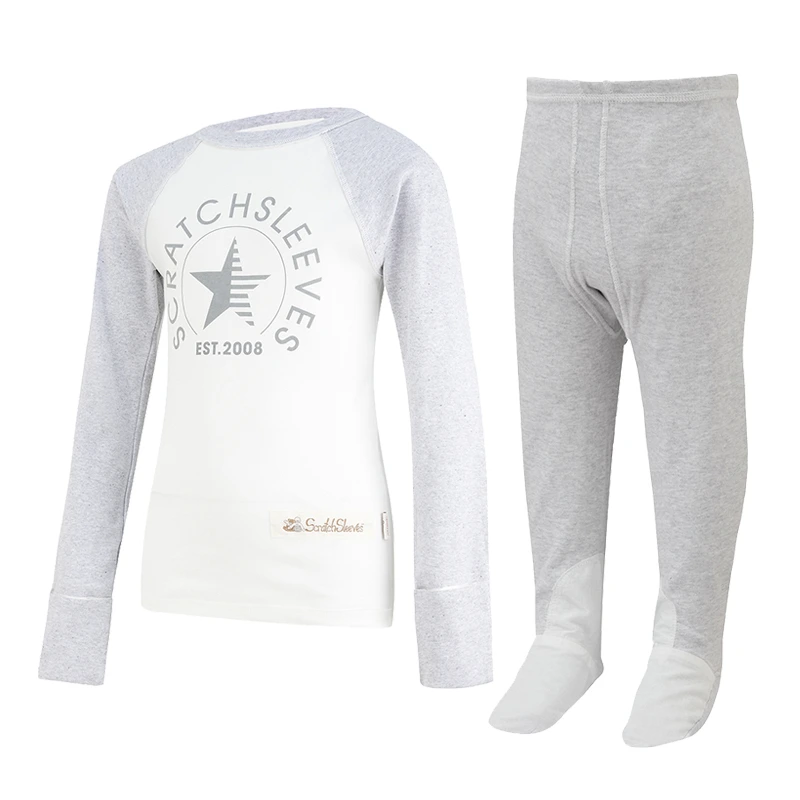 Vue de face du haut de pyjama ScratchSleeves pour enfants, style baseball, avec coutures extérieures aux épaules, à l'encolure et à l'ourlet. Corps blanc avec logo sérigraphié gris représentant un ours et est.2008. Encolure et manches en marron gris, avec les moufles repliées sur elles-mêmes. Corps en coton 100% et mitaines en soie naturelle 100%. Étiquette externe et marquage sur le côté gauche vers la base du haut. Vue de face de la salopette ScratchSleeves pour enfants, sans couture intérieure de la jambe et avec les pieds cousus. Pieds fermés avec une couche de coton tissé gris 100% sur le devant du pied et sous l'orteil. Corps sans manches en jersey de coton 100% vert seafoam, bordé d'un liseré de coton tissé gris sur le bras et l'encolure.