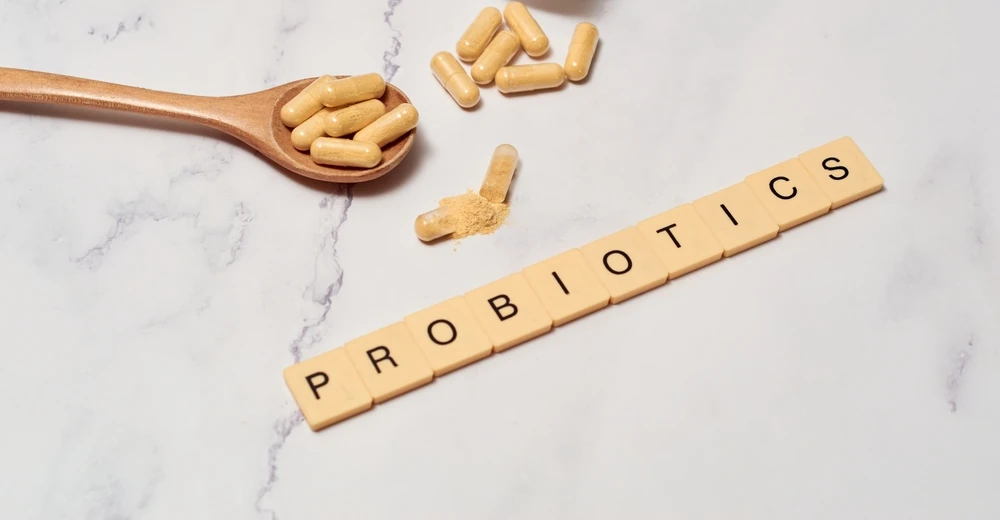 Capsules probiotiques orales sur surface en marbre avec lettres Scrabble épelant ' probiotiques '