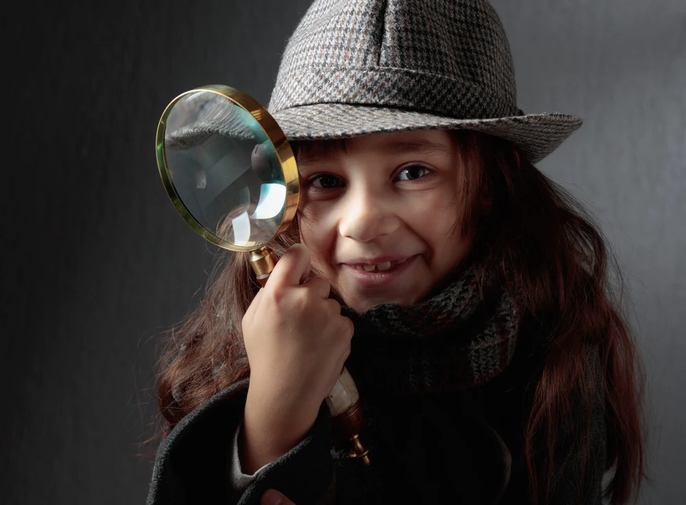 petite fille déguisée en détective victorien avec un chapeau en tweed et une loupe