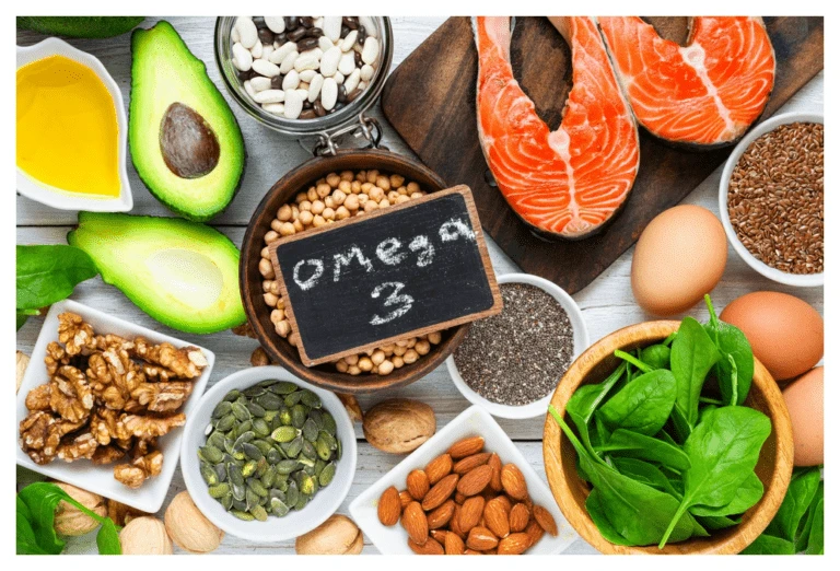 Selection of colourful foods rich in omega 3 including salmon, eggs, seeds, nuts and avocados.
