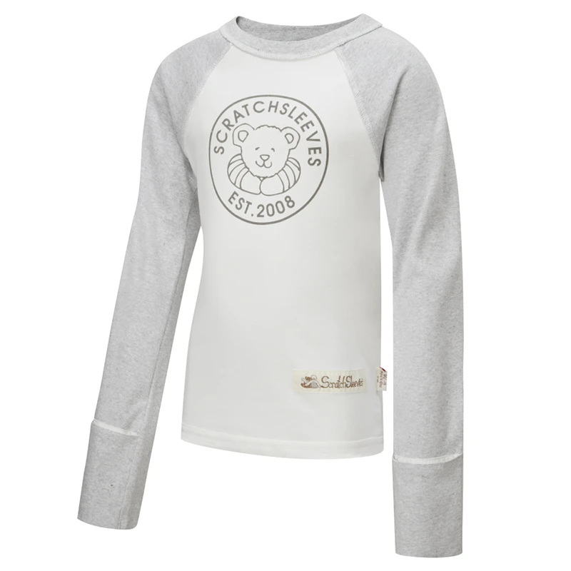 Vue de face du haut de pyjama ScratchSleeves pour enfants, style baseball, avec coutures extérieures aux épaules, à l'encolure et à l'ourlet. Corps blanc avec logo sérigraphié gris représentant un ours et est.2008. Encolure et manches en marron gris, avec les moufles repliées sur elles-mêmes. Corps en coton 100% et mitaines en soie naturelle 100%. Étiquette externe et marquage sur le côté gauche, à la base du haut.