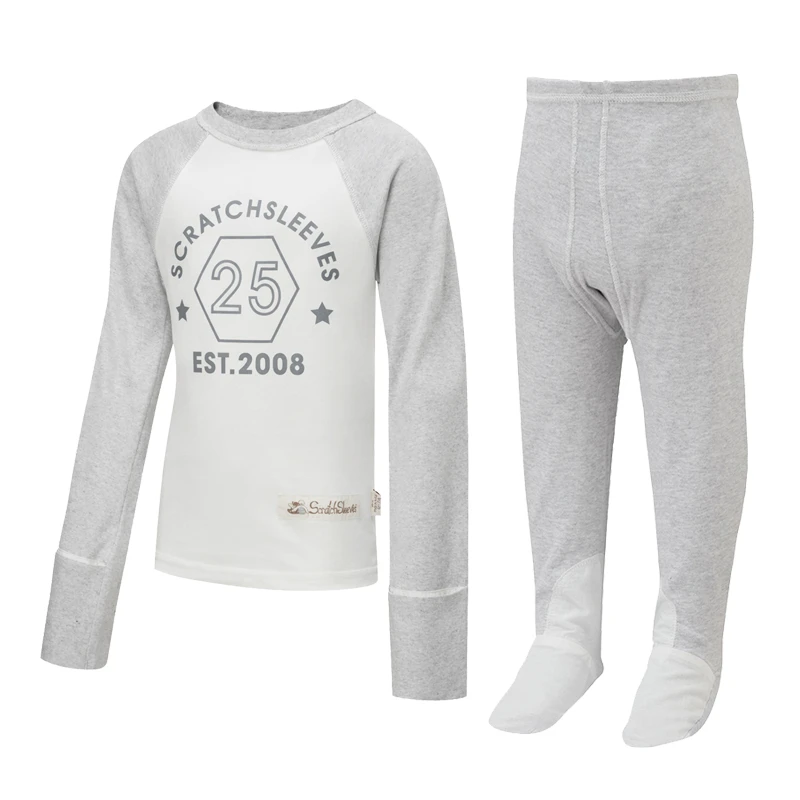 Vorderansicht des Kinder-Pyjama-Oberteils im Baseball-Stil mit Klapp-Fäustlingen von ScratchSleeves mit äußeren Schulter-, Nacken- und Saumnähten. Weißer Körper mit grauem Siebdrucklogo, das ein Sechseck und "est. 2008" zeigt. Grau melierter Nacken und Ärmel, mit zurückgeklappten Fäustlingen. 100% Baumwollkörper und 100% Seidenfäustlinge. Externes Etikett und Branding auf der linken Seite am unteren Rand des Oberteils. Vorderansicht der Kinder-Latzhose von ScratchSleeves in Seegrün mit keiner Innenbein-Naht und eingenähten Füßen. Geschlossene Füße mit einer Schicht aus grauem, 100% gewebtem Baumwollstoff über der Vorderseite des Fußes und unter den Zehen. Seegrün oliv, ärmelloser Körper aus 100% Baumwolljersey, eingefasst mit grauem, gewebtem Baumwollband an Arm und Hals.